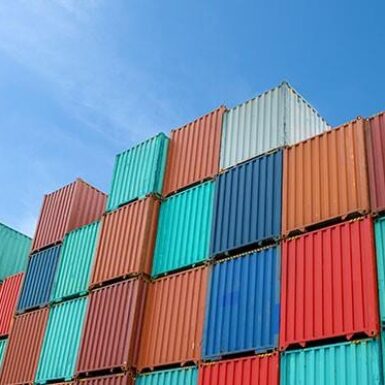 Colourful shipping containers with plane flying overhead